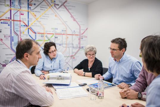 5 people in a room with a public transport network map